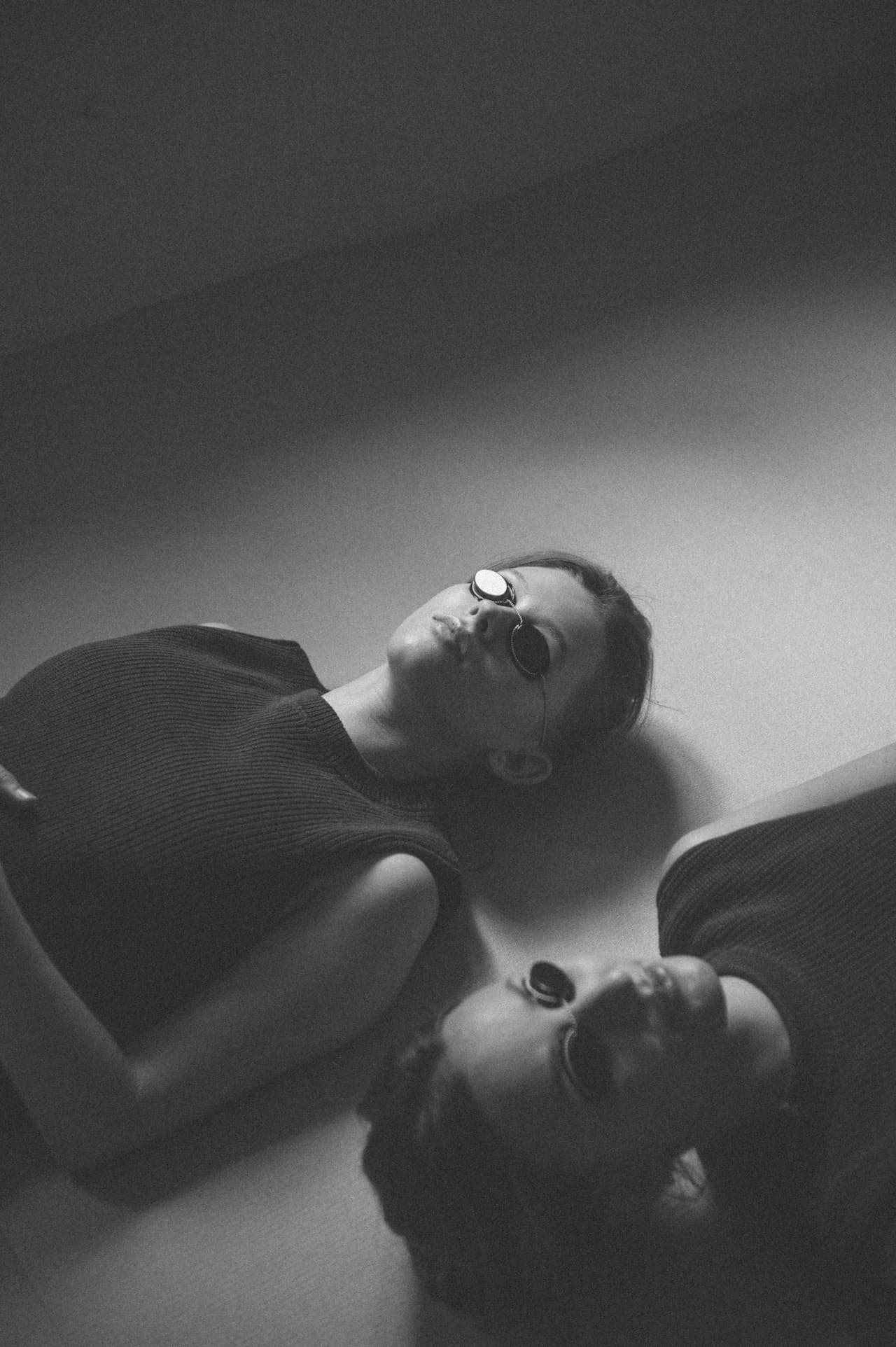 Two people resting, eyes closed, in soft light